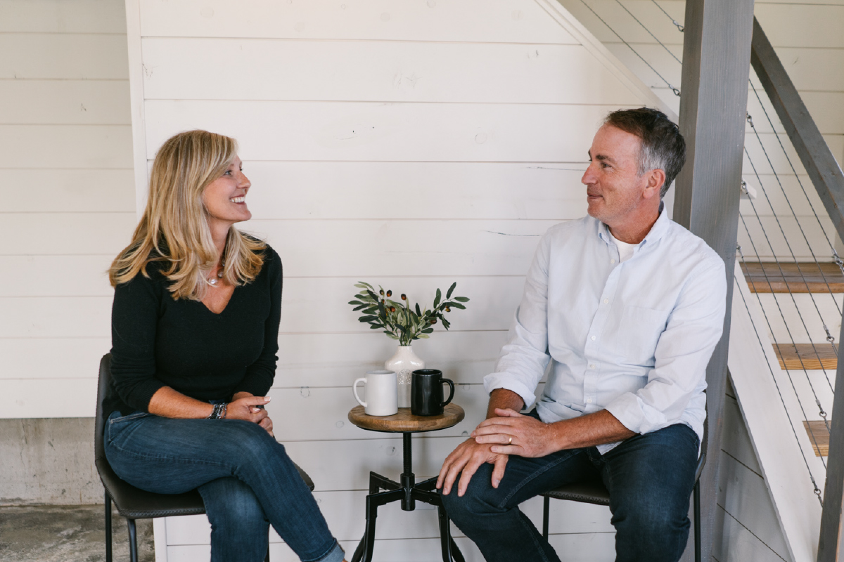 Steve and Lisa sitting in chairs smiling at each other