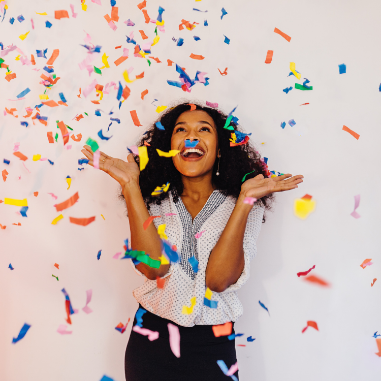 Woman smiling and throwing confetti in the air