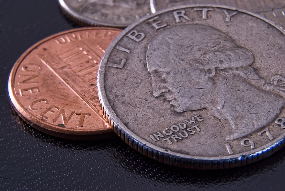 A US quarter coin laying atop a US penny, close up...very close up >_<