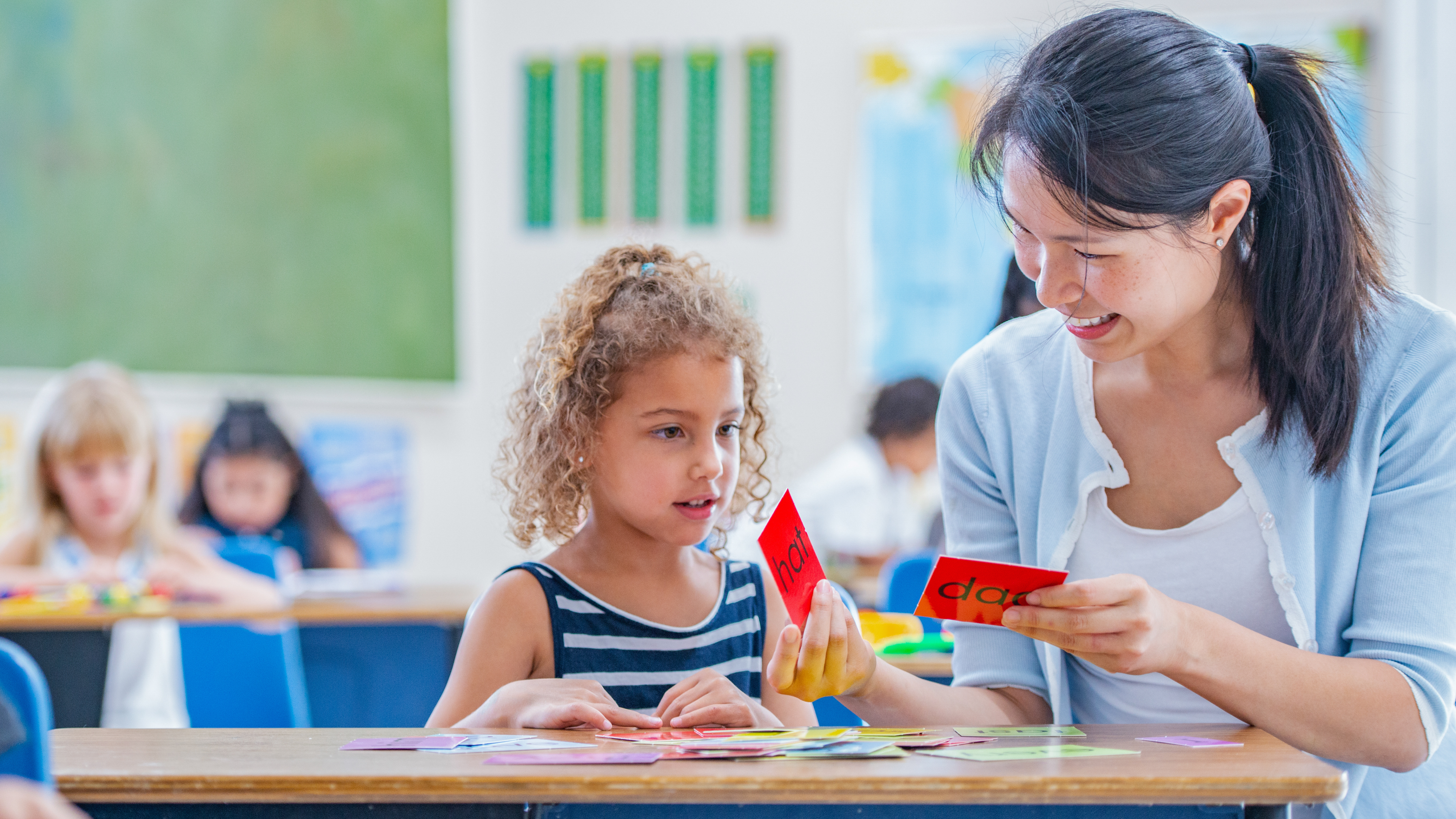 student working with a teacher using flash cards