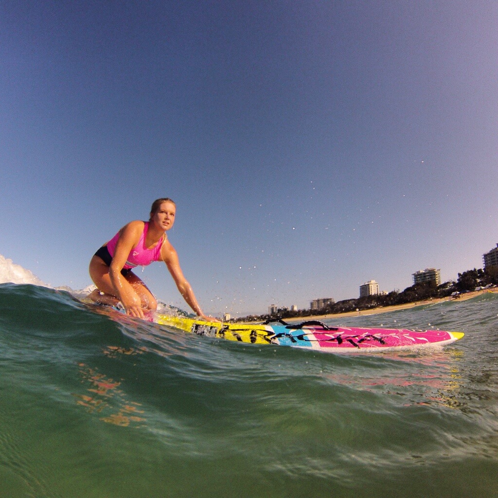 Eva riding a wave on a kracka paddleboard in maroochydore australia