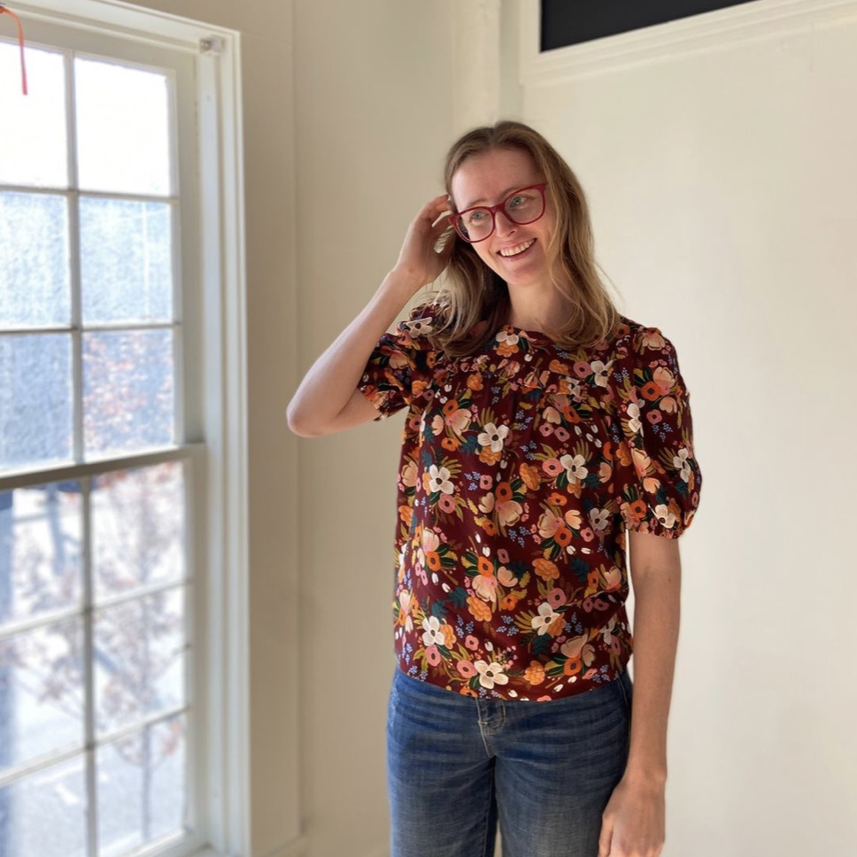 Woman in a floral blouse next to 