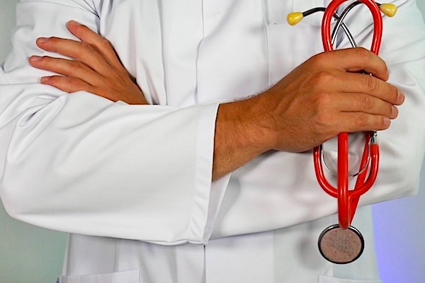 Man in white coat holding a stethoscope