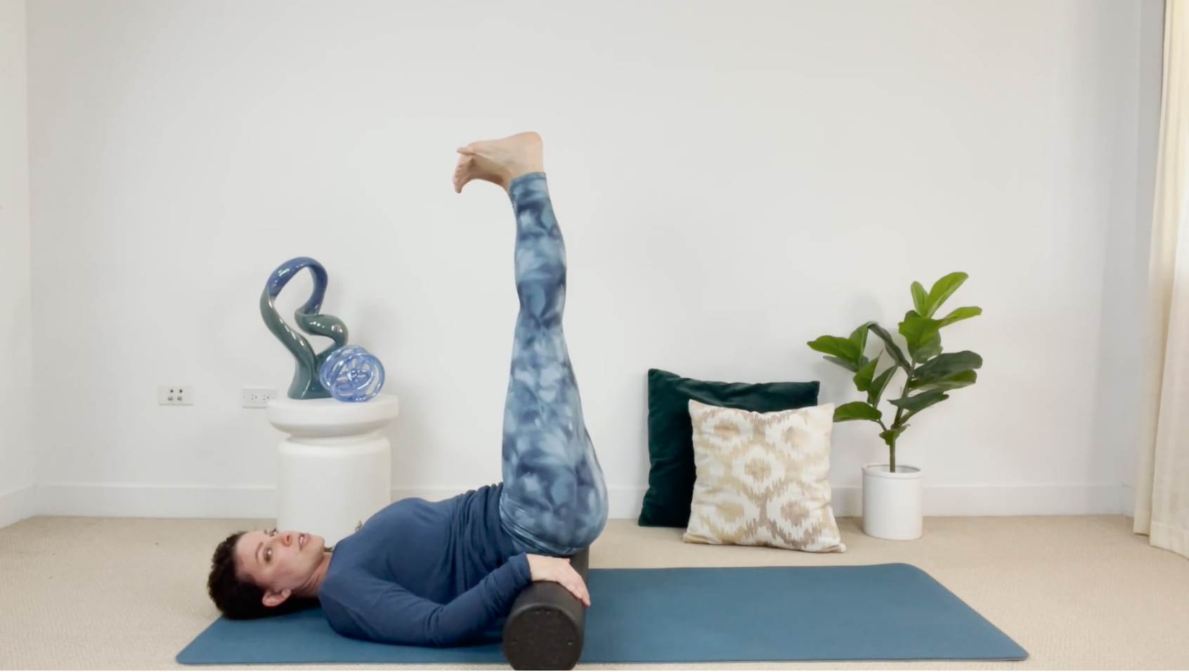 Self treating the sacrum bone with woman laying hips on a foam roller