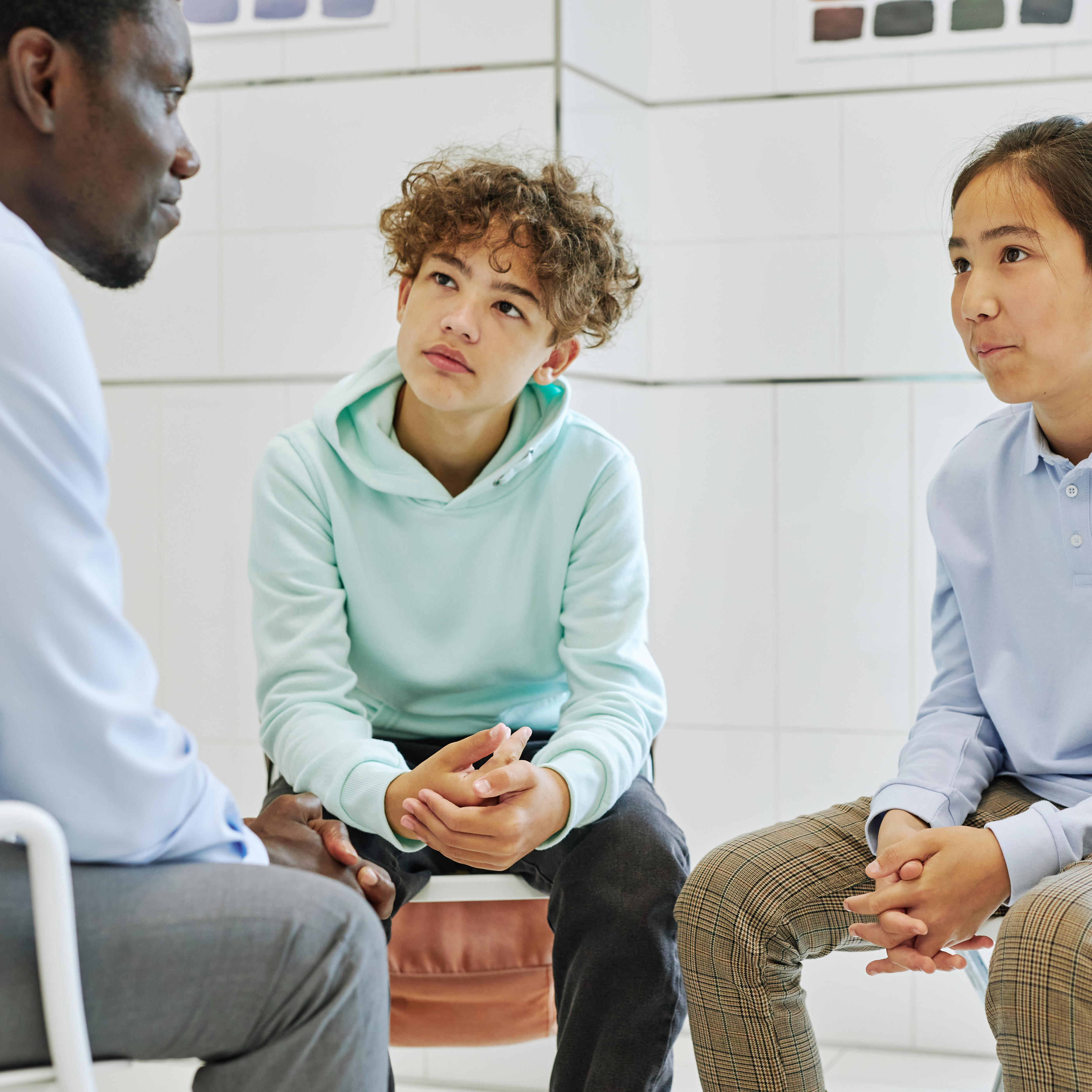 teacher talking with two students in serious conversation