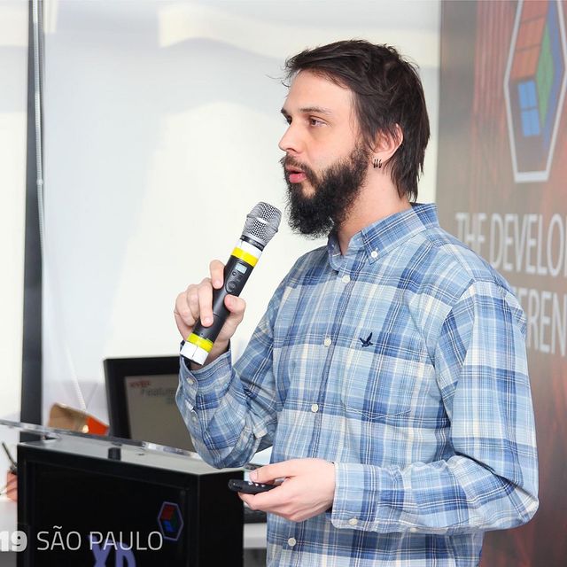 Foto de Marcio Frayze David dando uma palestra em uma conferência.