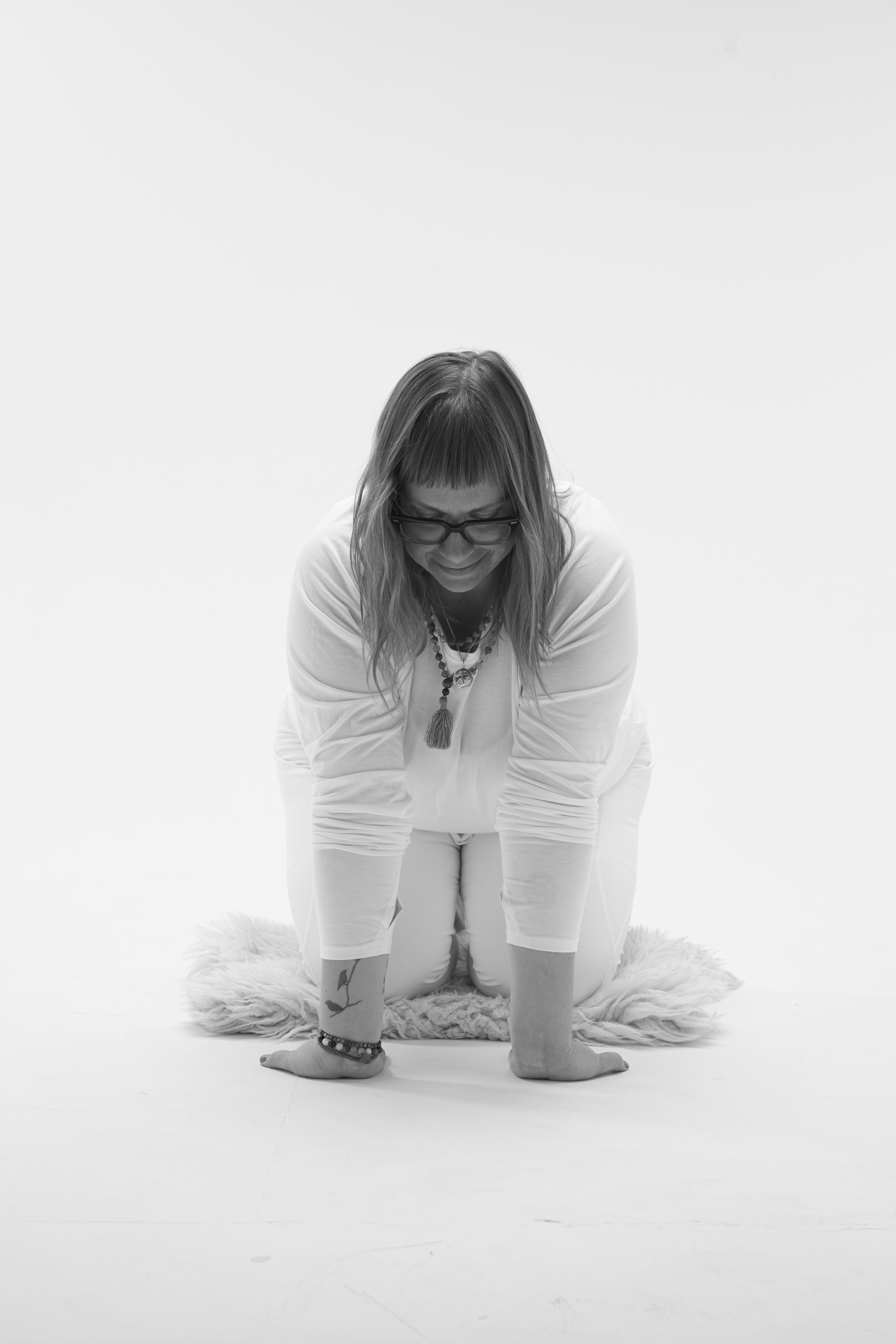 black and white image of yin yoga teacher Amanda Flott-Kinsey demonstrating big cat pose