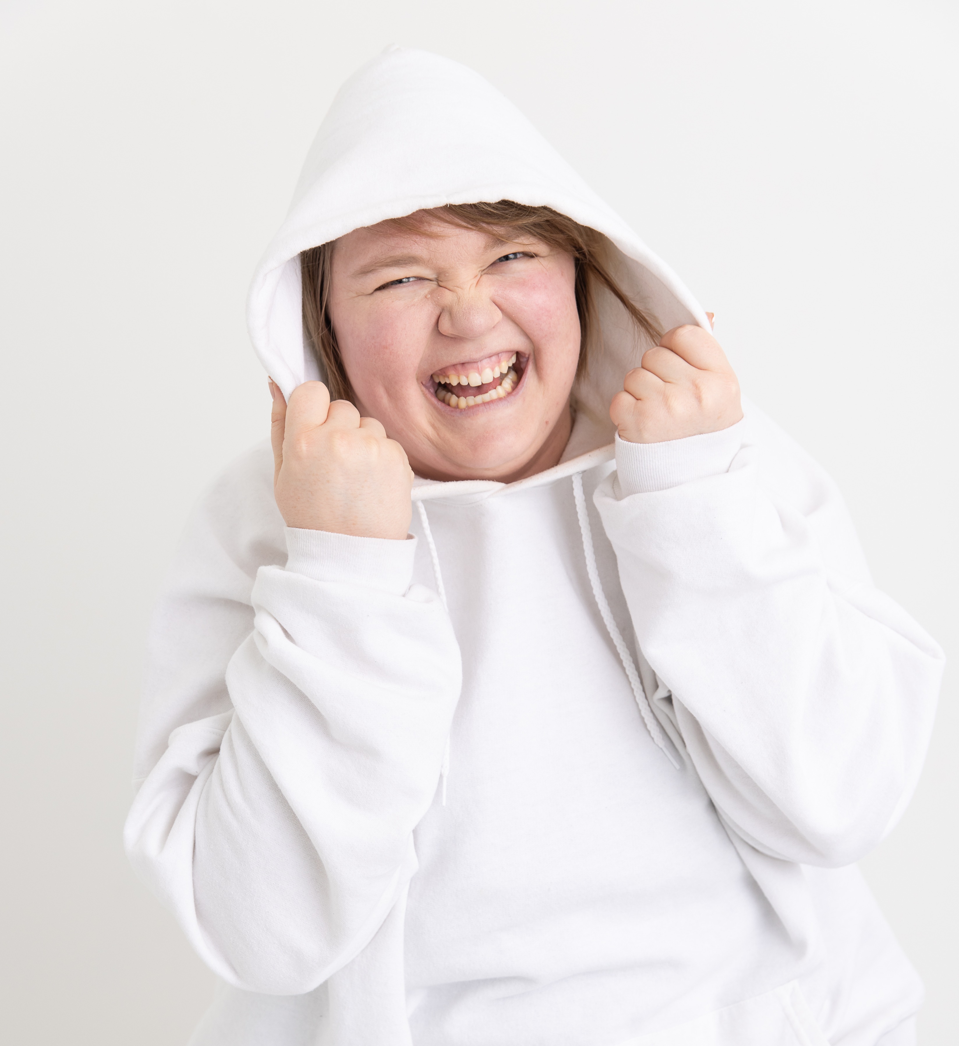 Kami wearing a white hoodie pulled up over her head with a big smile