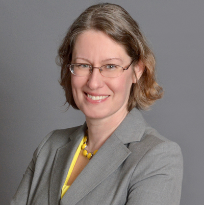 Barbara in a gray suit, smiling