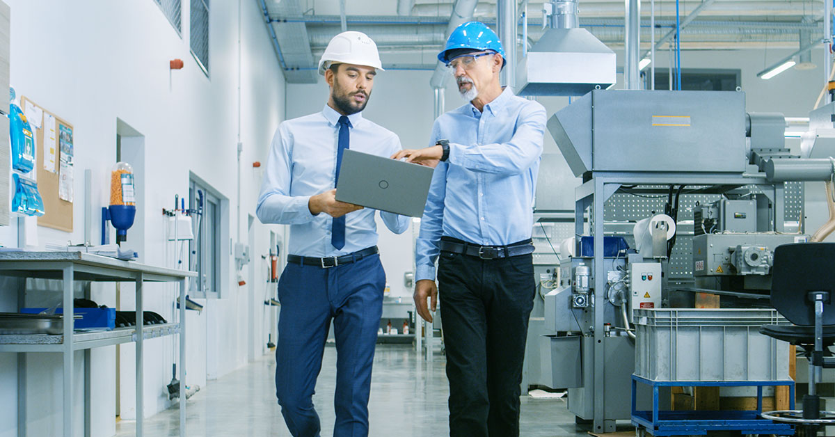 Two men walking a machine shop