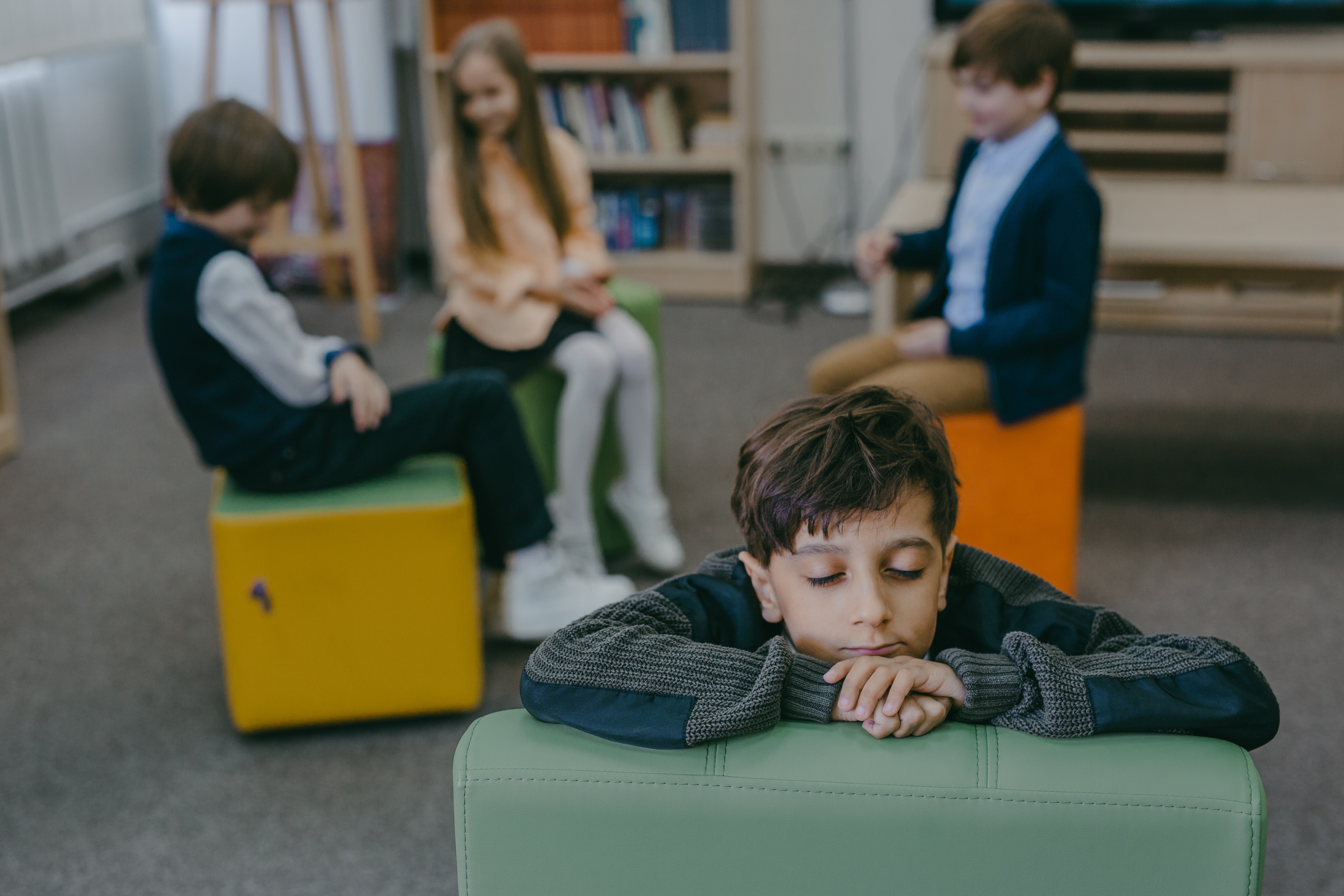 sad student with his head down away from the group