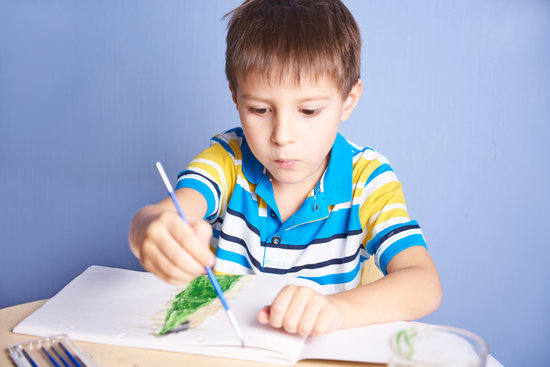Boy painting in a book