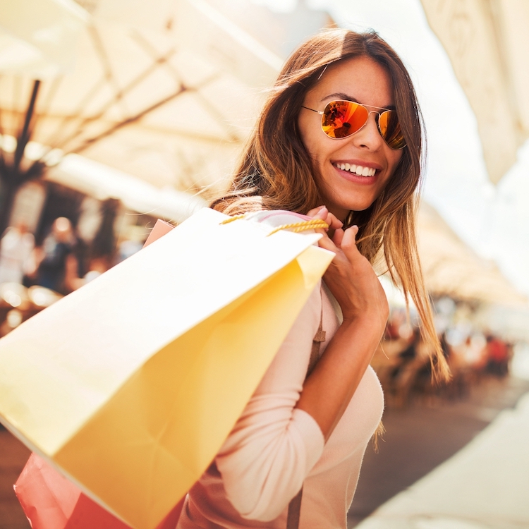 smiling, confident woman with shopping bags