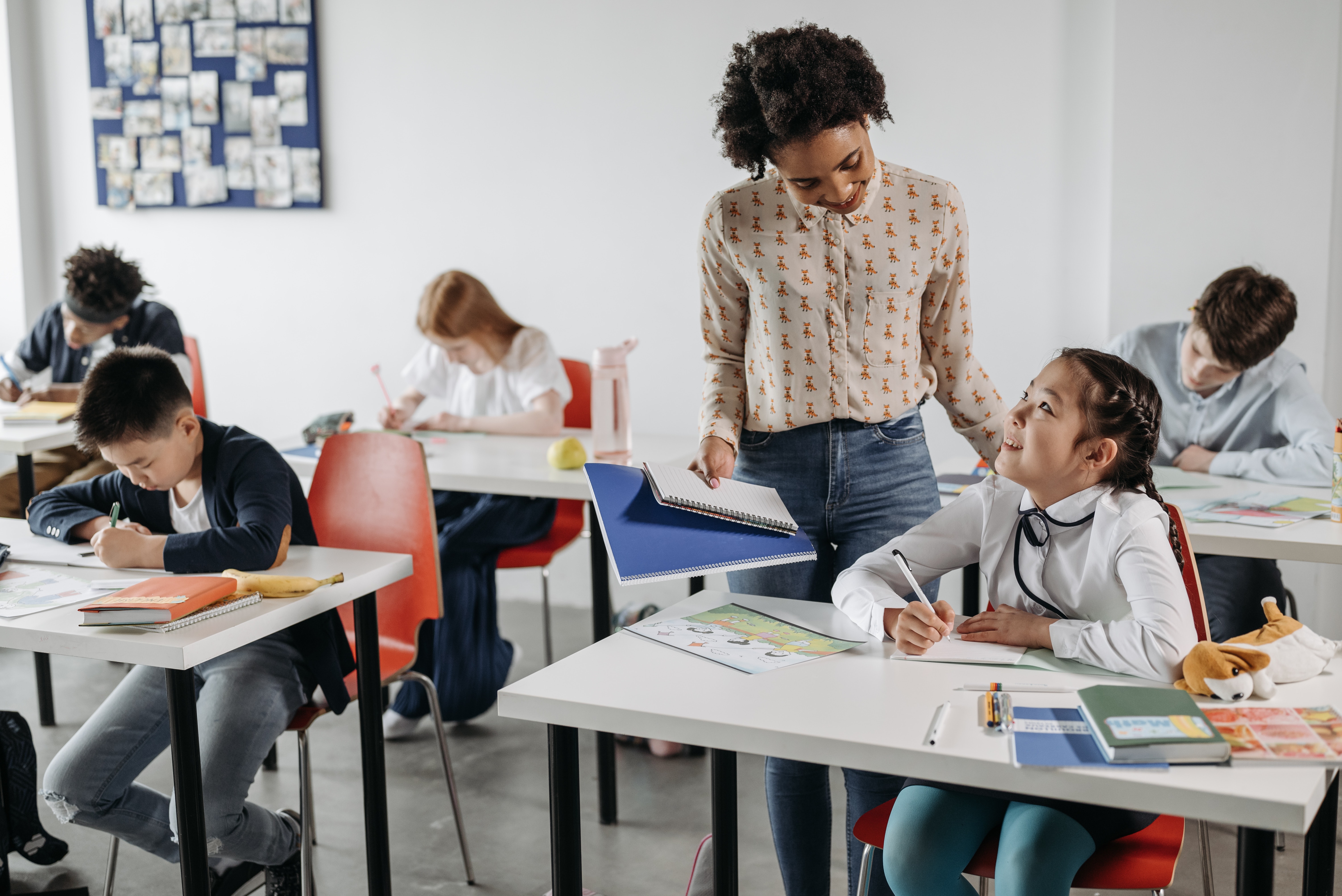 teacher standing next to student with hand on shoulder