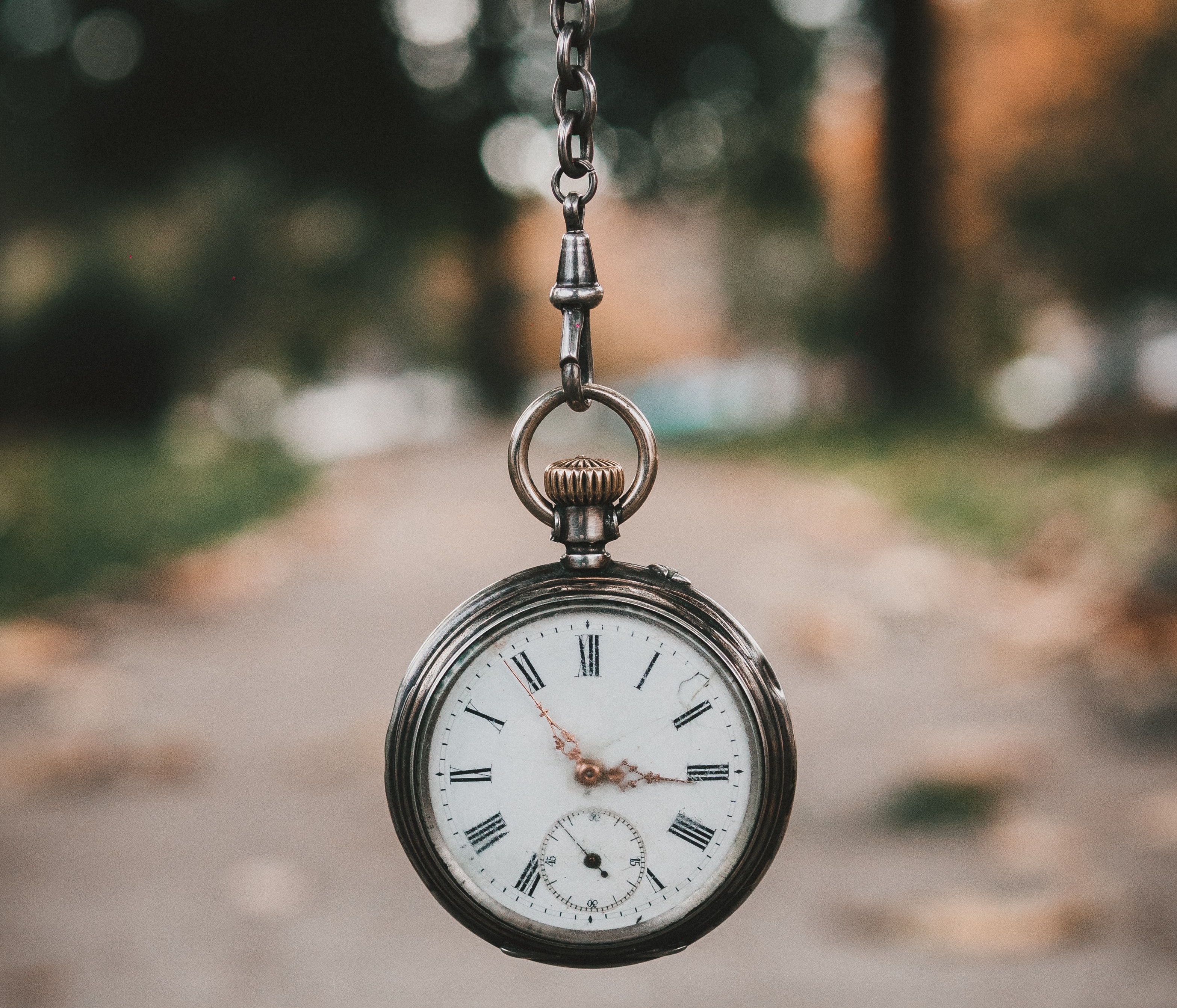 Pocket watch hanging in front of a blurred background