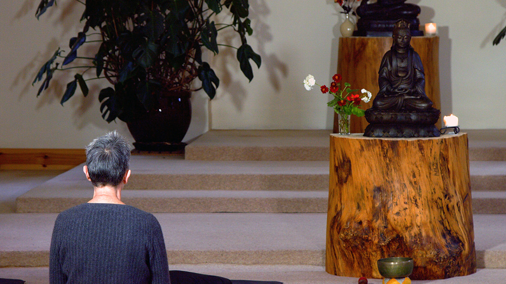 Laura meditating in front of Kuan Yin statue