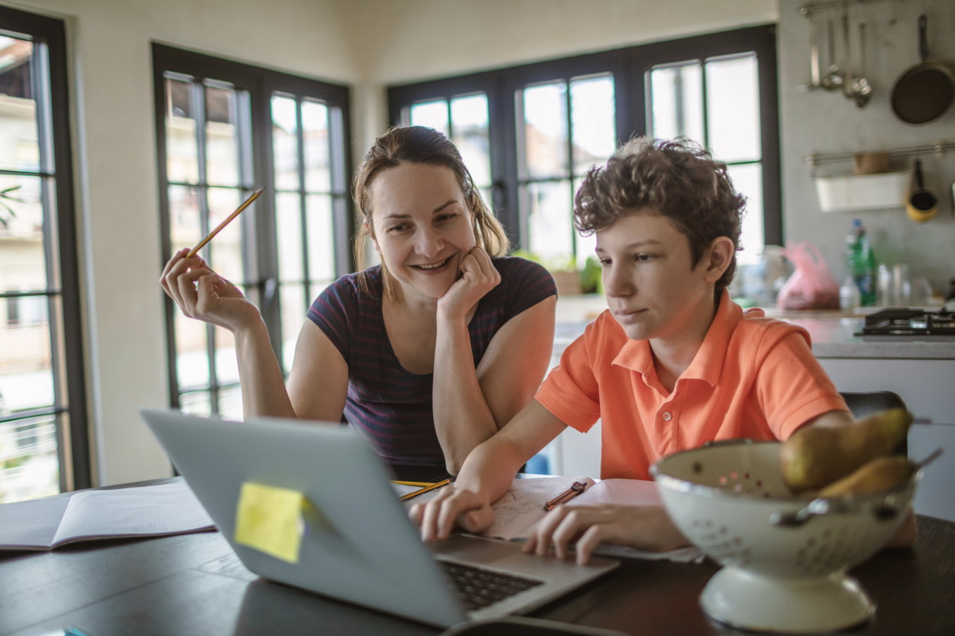 A mom helps her son with homework.