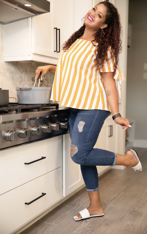 Tamara Johnson wearing a yellow and white striped shirt, cooking in the kitchen