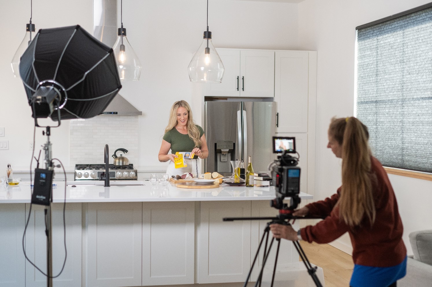 Chef Siiri Sampson sets up a cooking class in a white kitchen on set with professional lighting and camera.