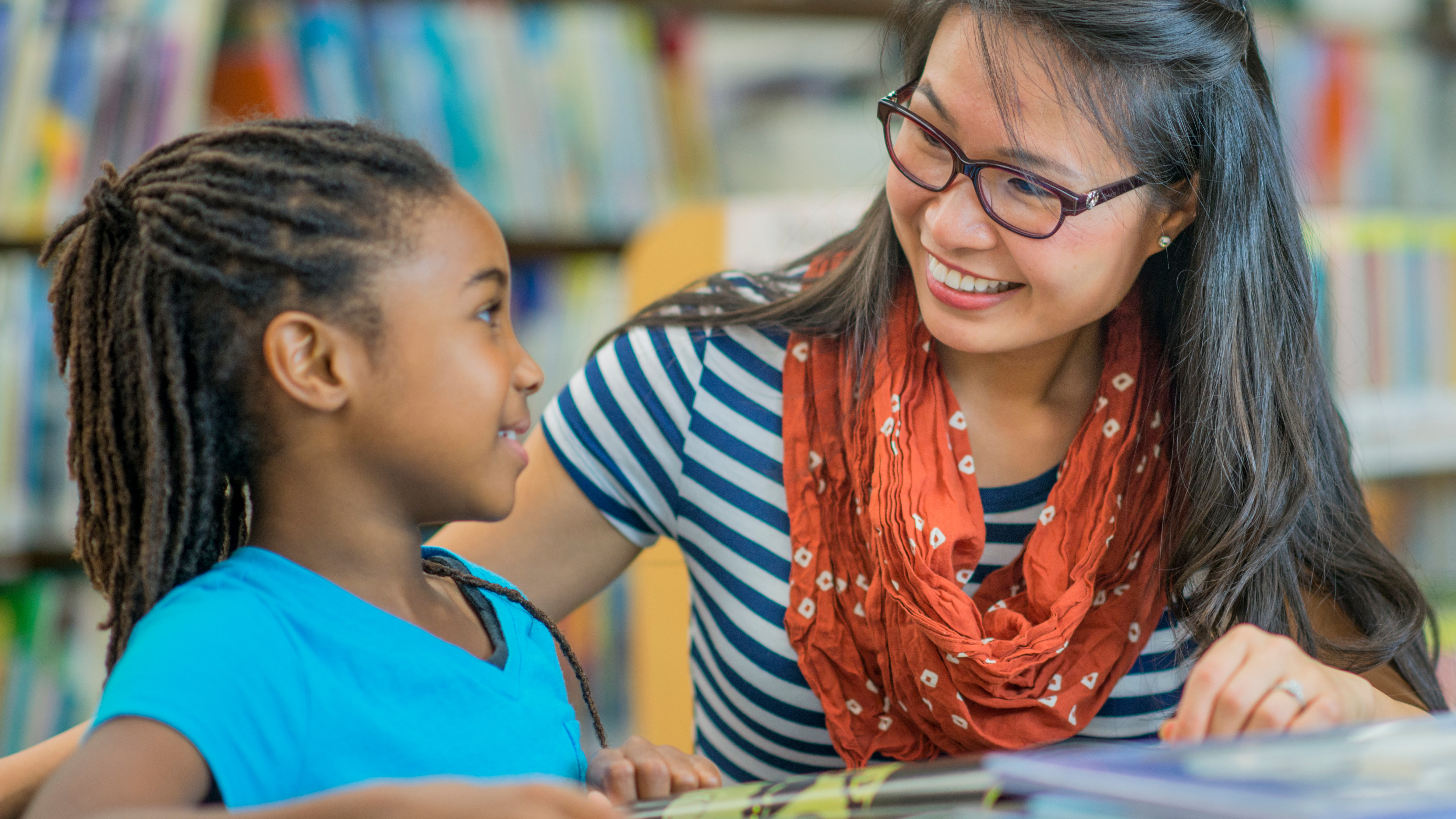 teacher working with student and smiling