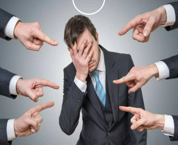 Man covering his face as if in shame with six hands with index fingers pointing at him