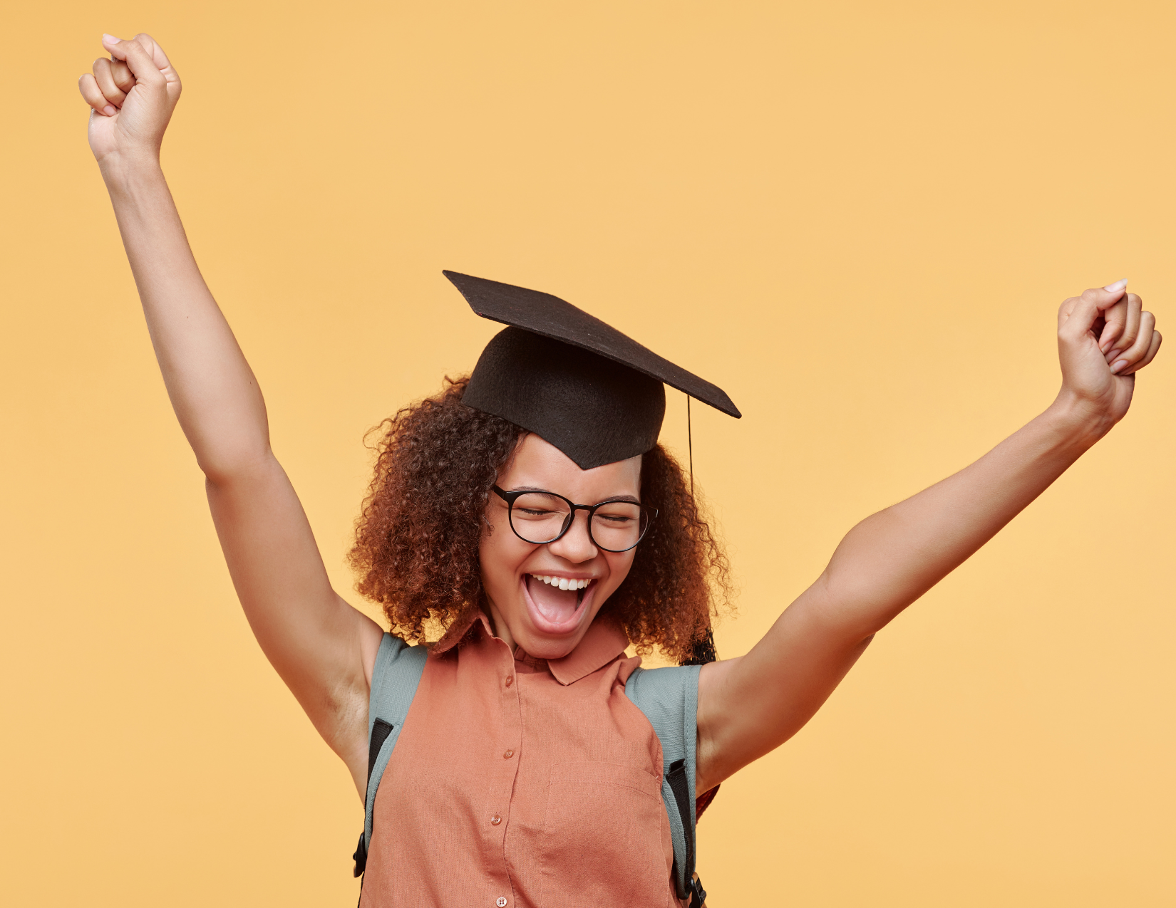 Woman in grad cap cheering for herself.