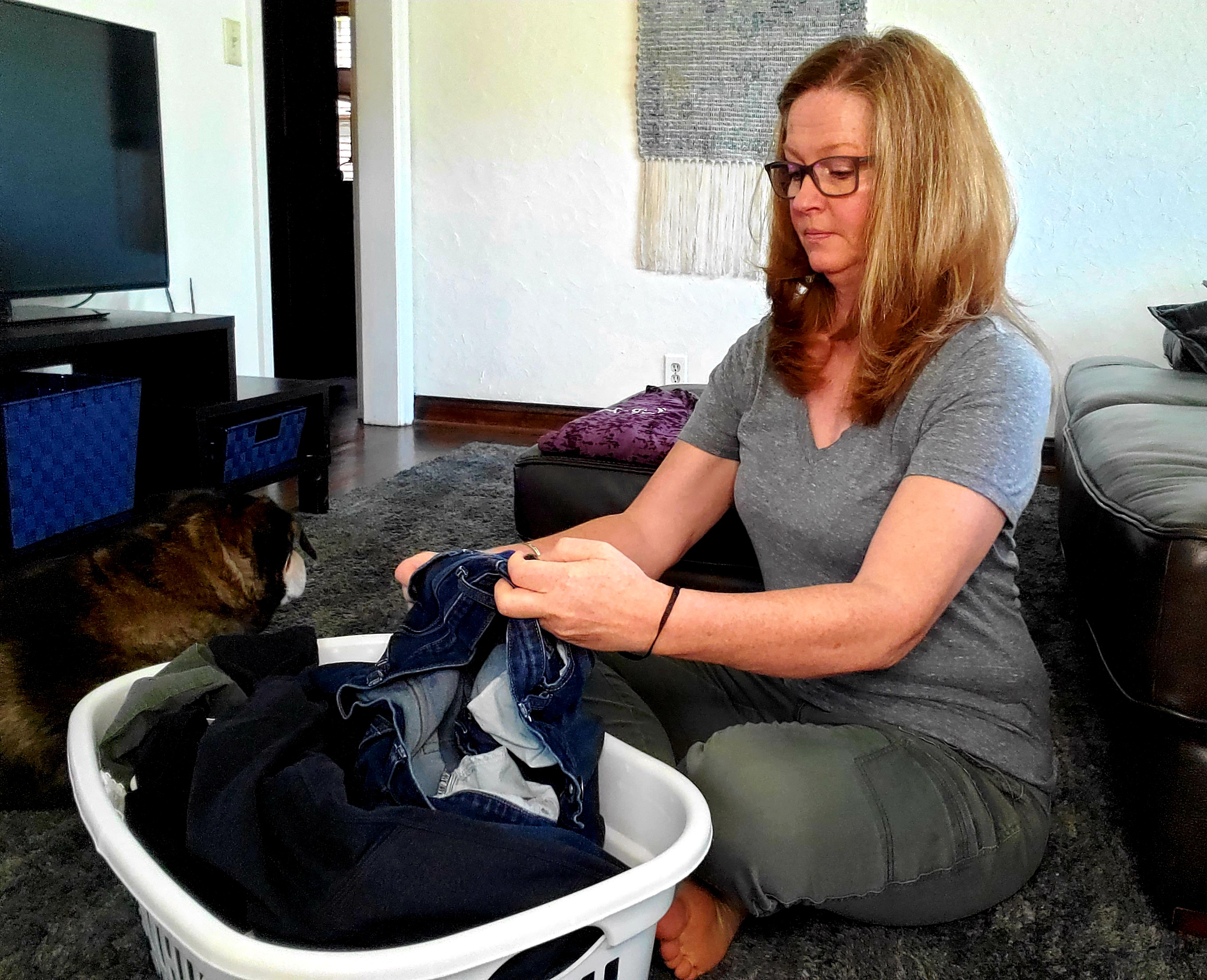 woman folding laundry on the floor
