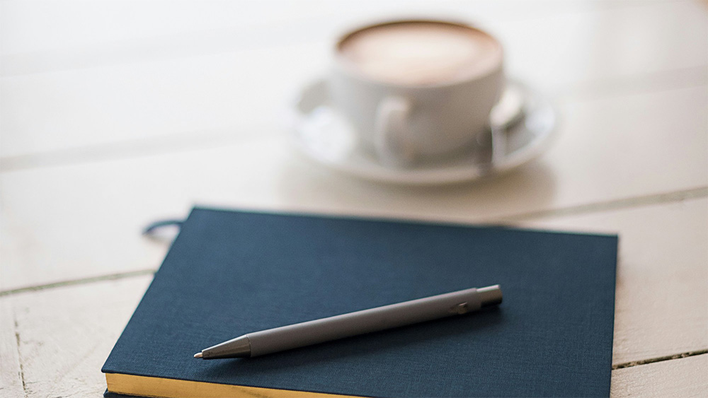 A coffee cup and notebook