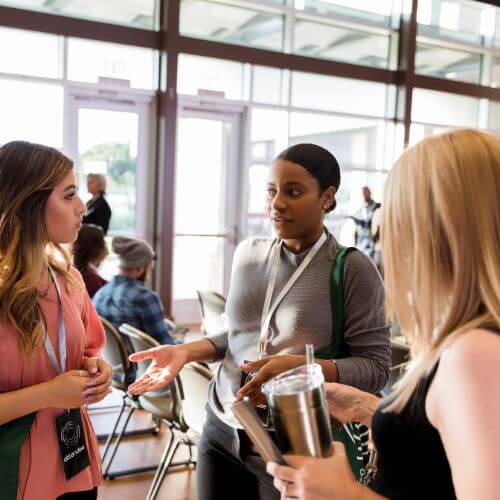 Three people having a conversation after a conference session