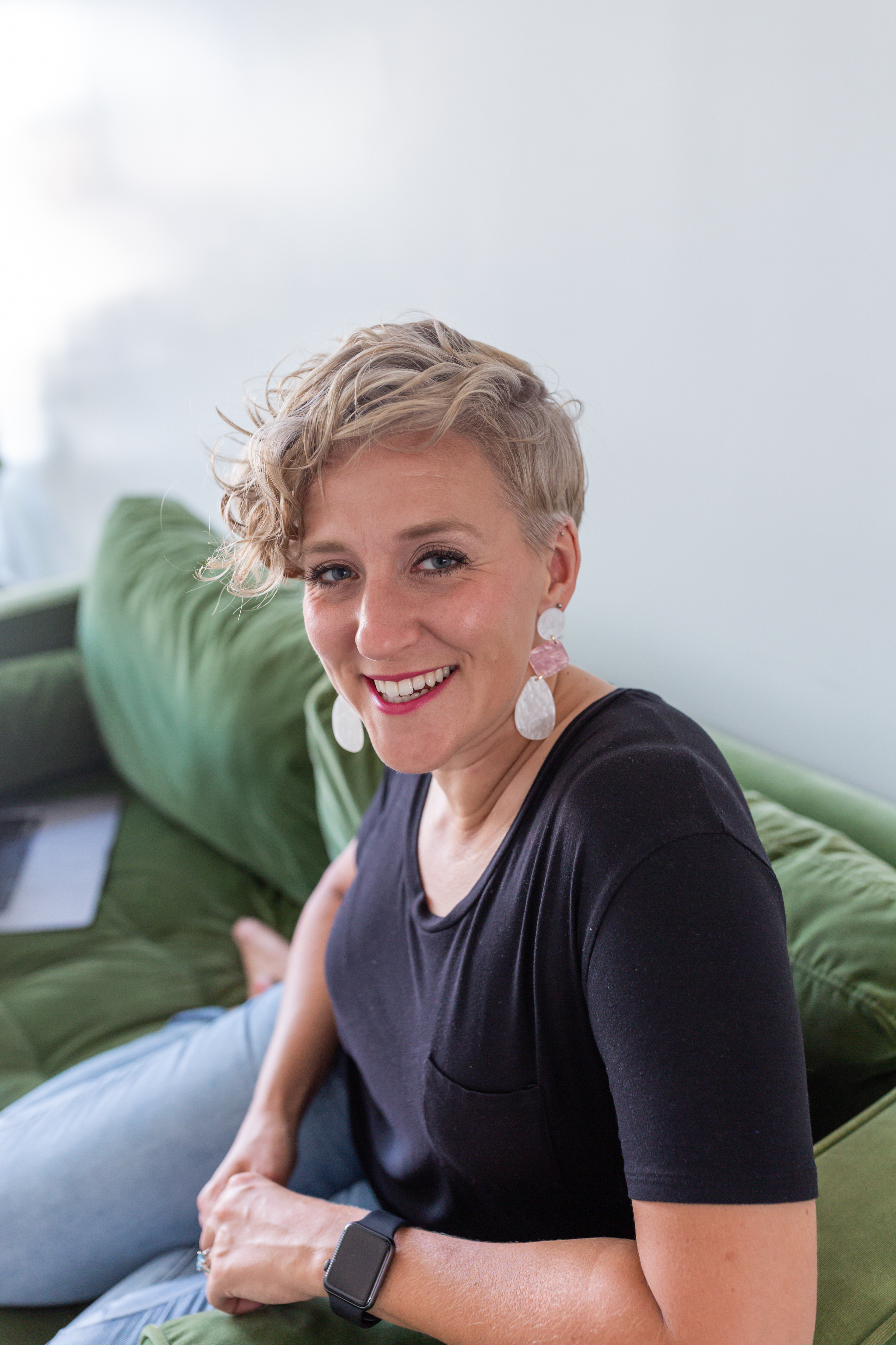 social media coach, blonde curly hair girl on green couch