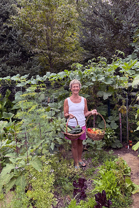Laurie Brautigam harvesting cucumbers and tomatoes