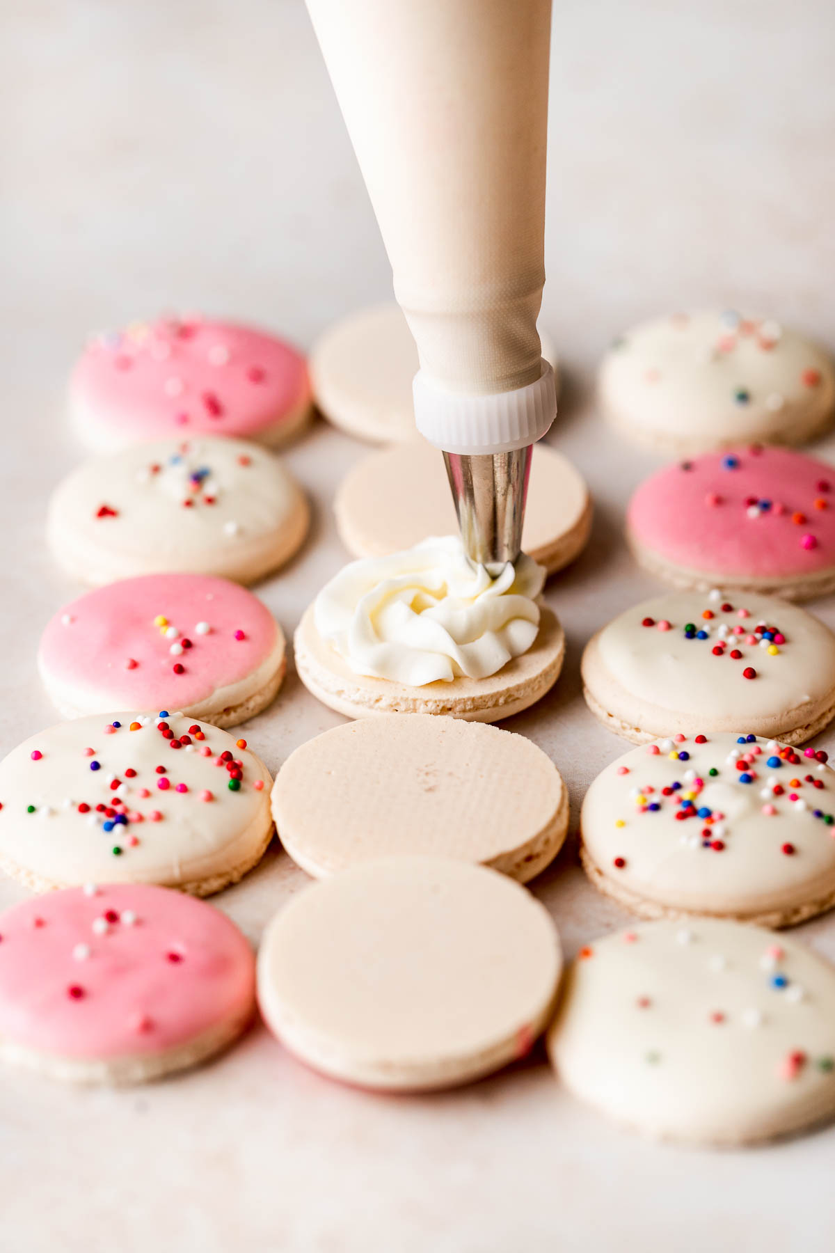 piping buttercream onto a macaron shell