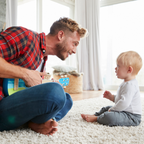 dad plays ukulele to baby