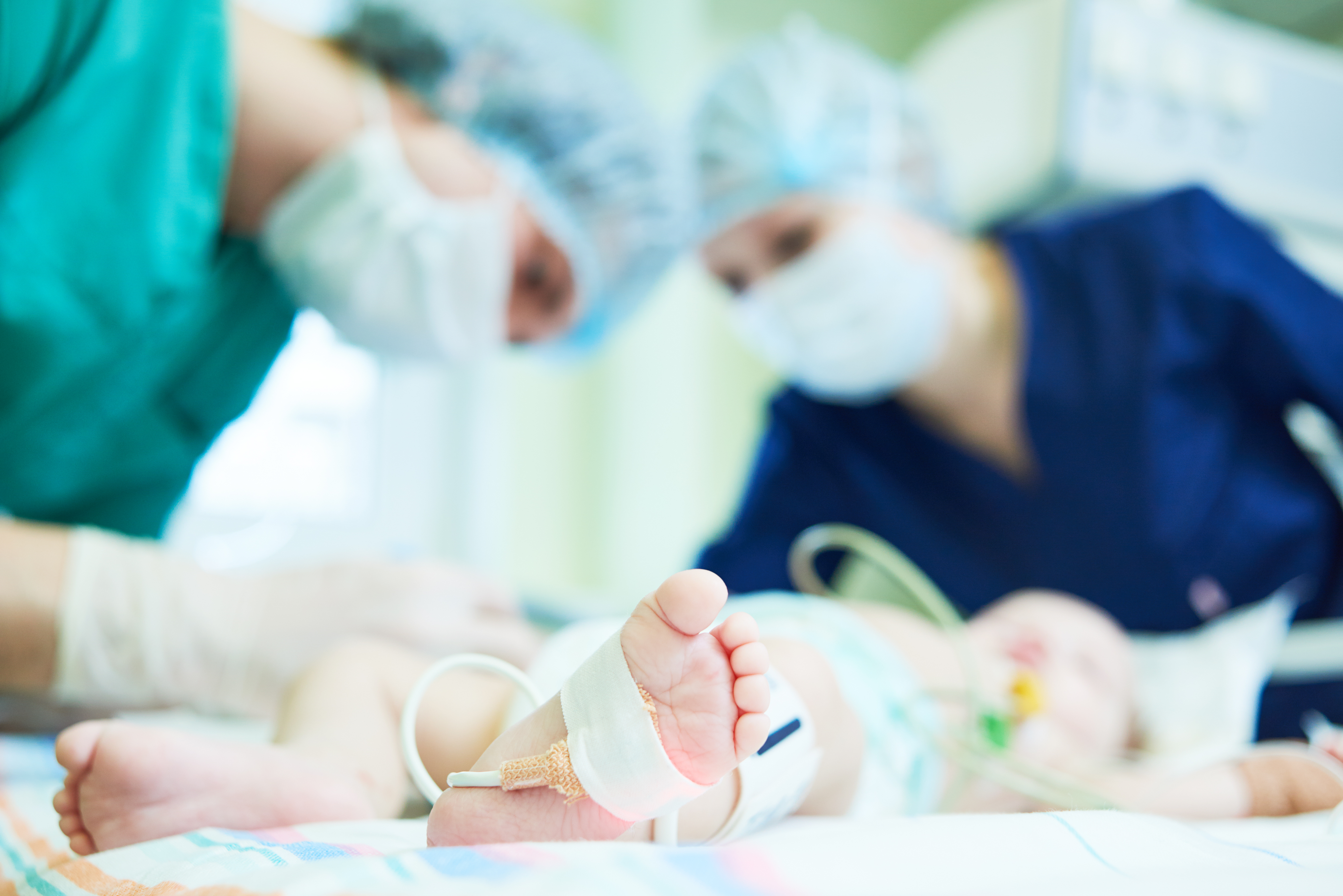 Two NICU nurses taking care of an infant