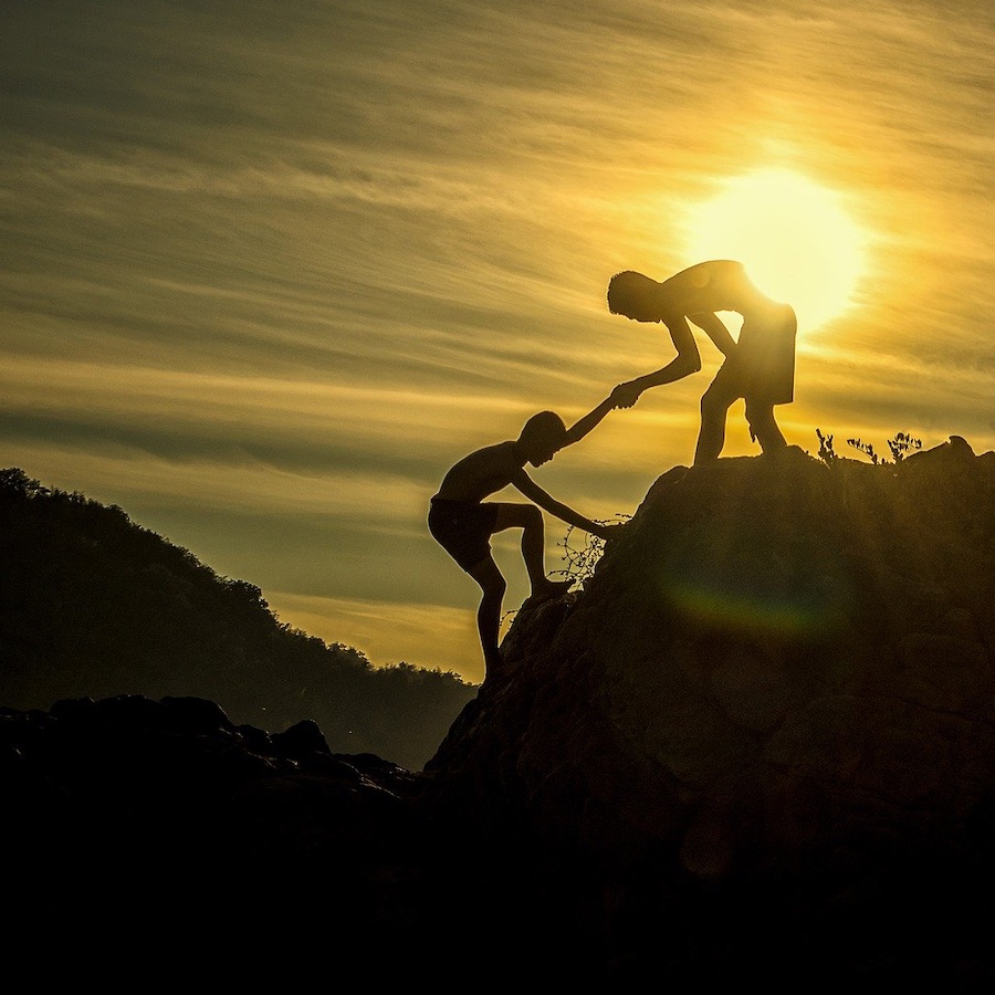 Person being helped up a mountain