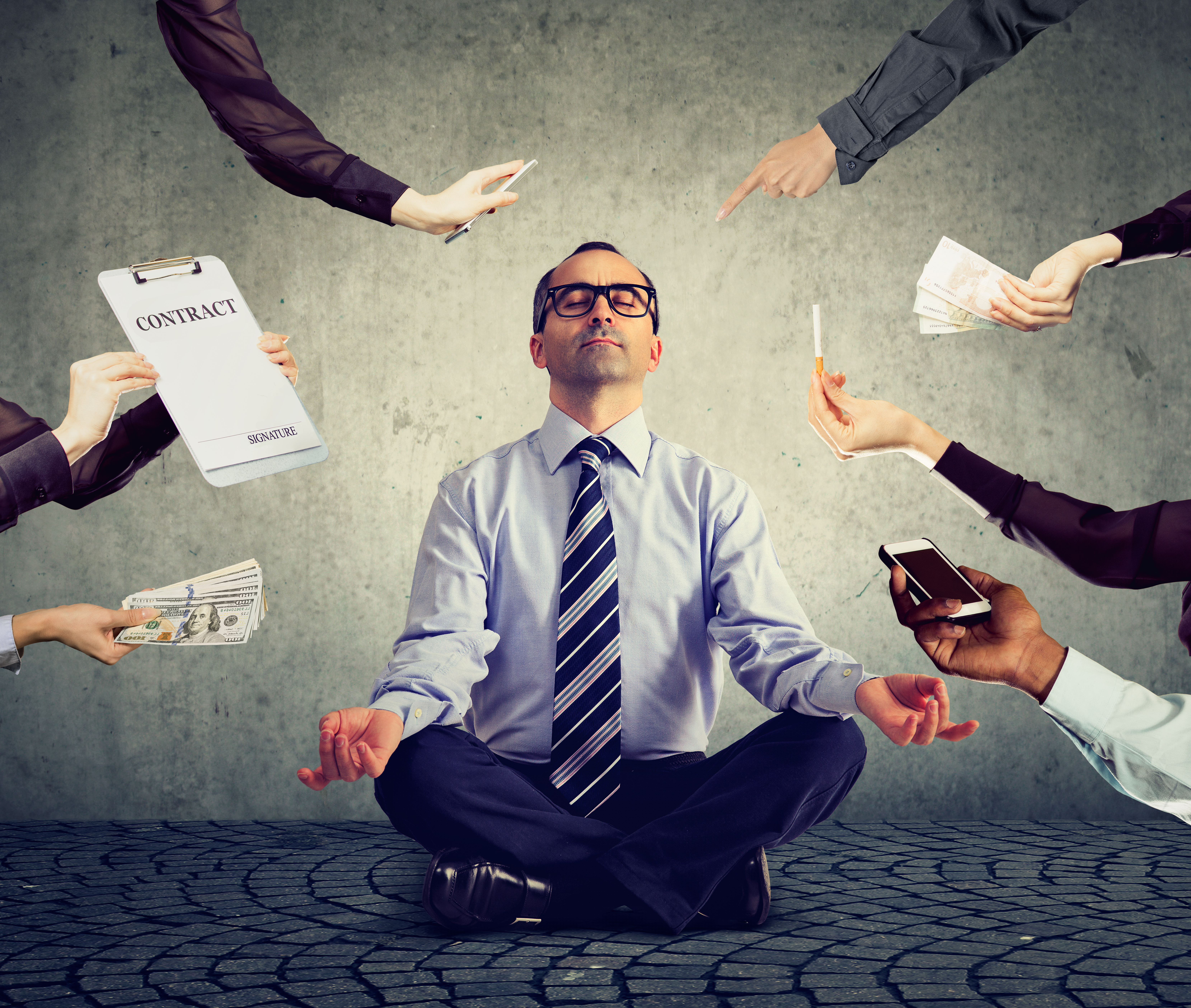 Man in glasses and business attire meditating while arms are seen attempting to distract him with money, cigarette, phone, contracts, etc. 