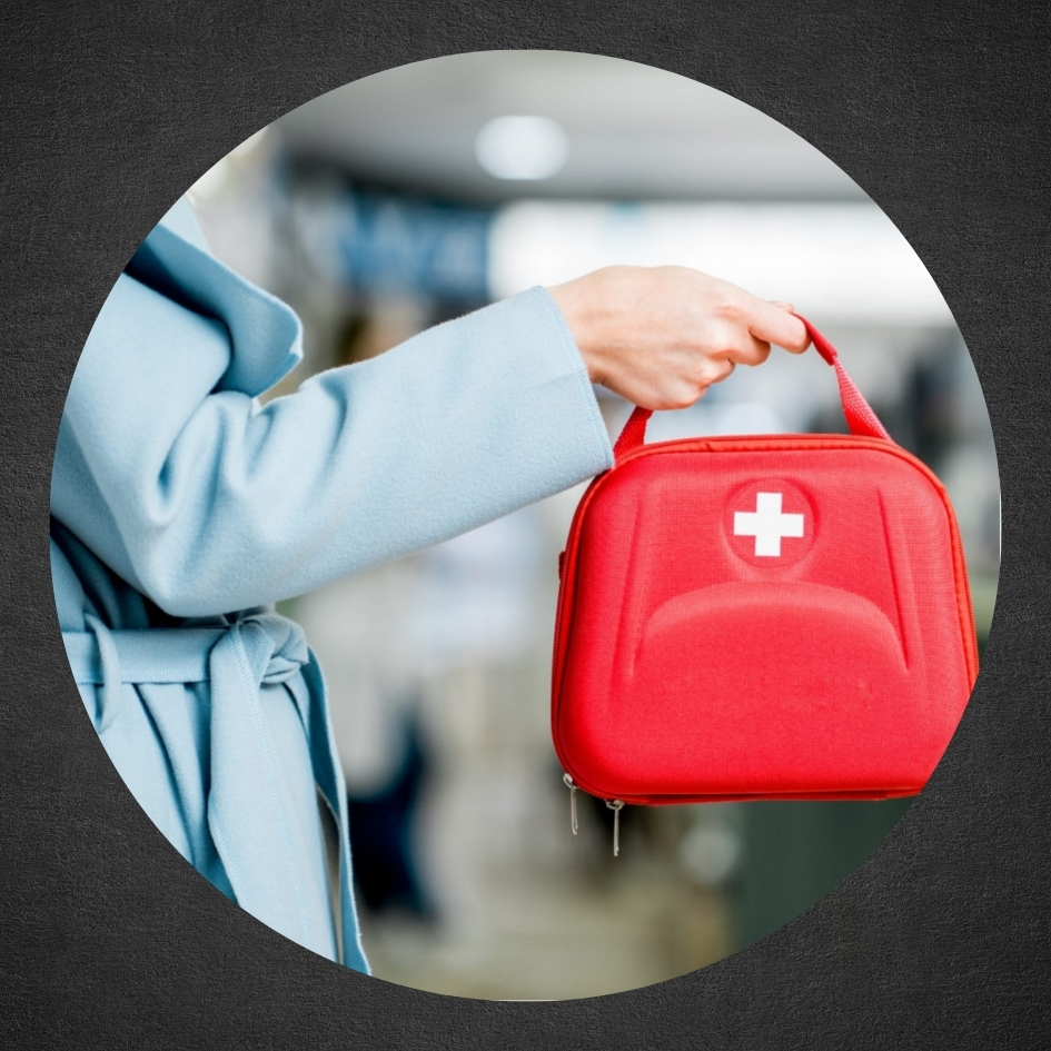 woman in blue coat holding red emergency bag
