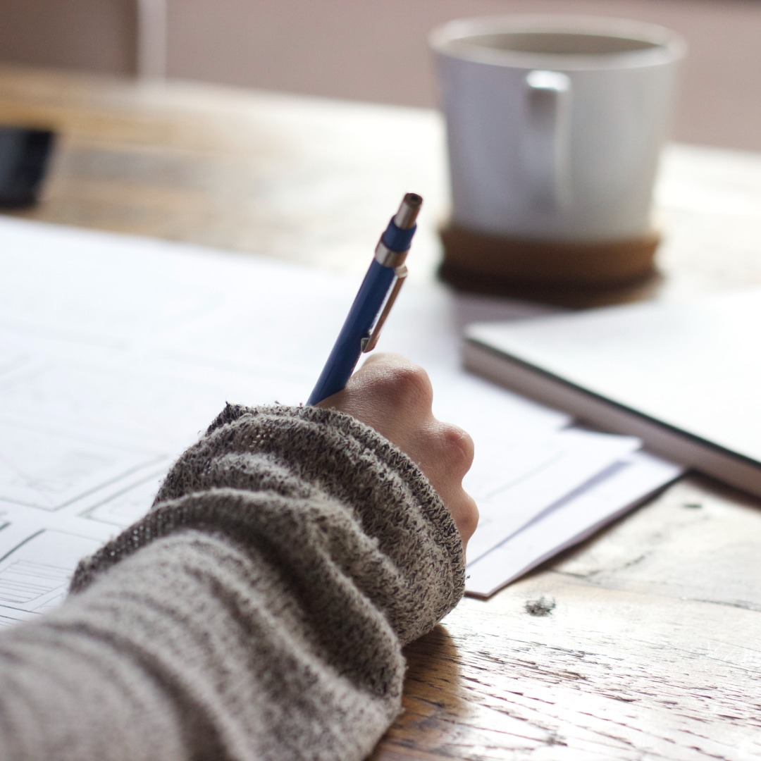 Hand writing with cup of coffee