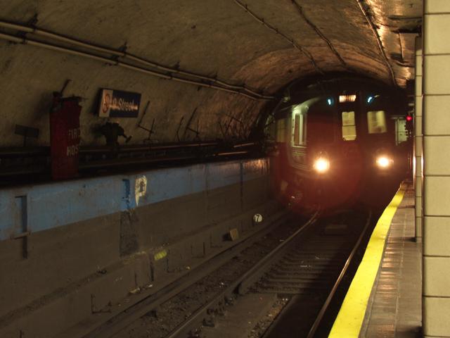 Train approaching subway station from tunnel.