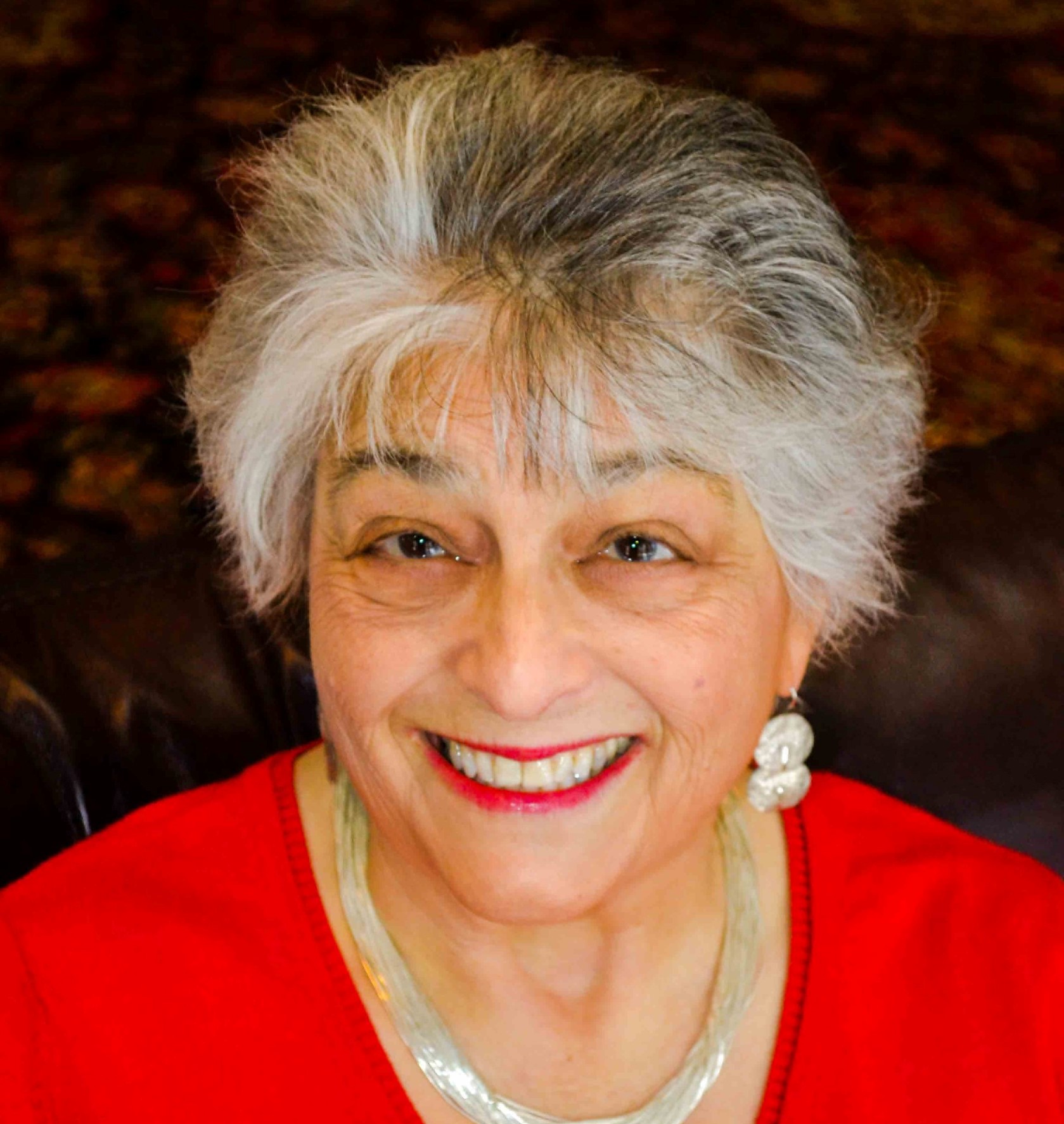 Dr. Elana Sztokman standing in front of a book case