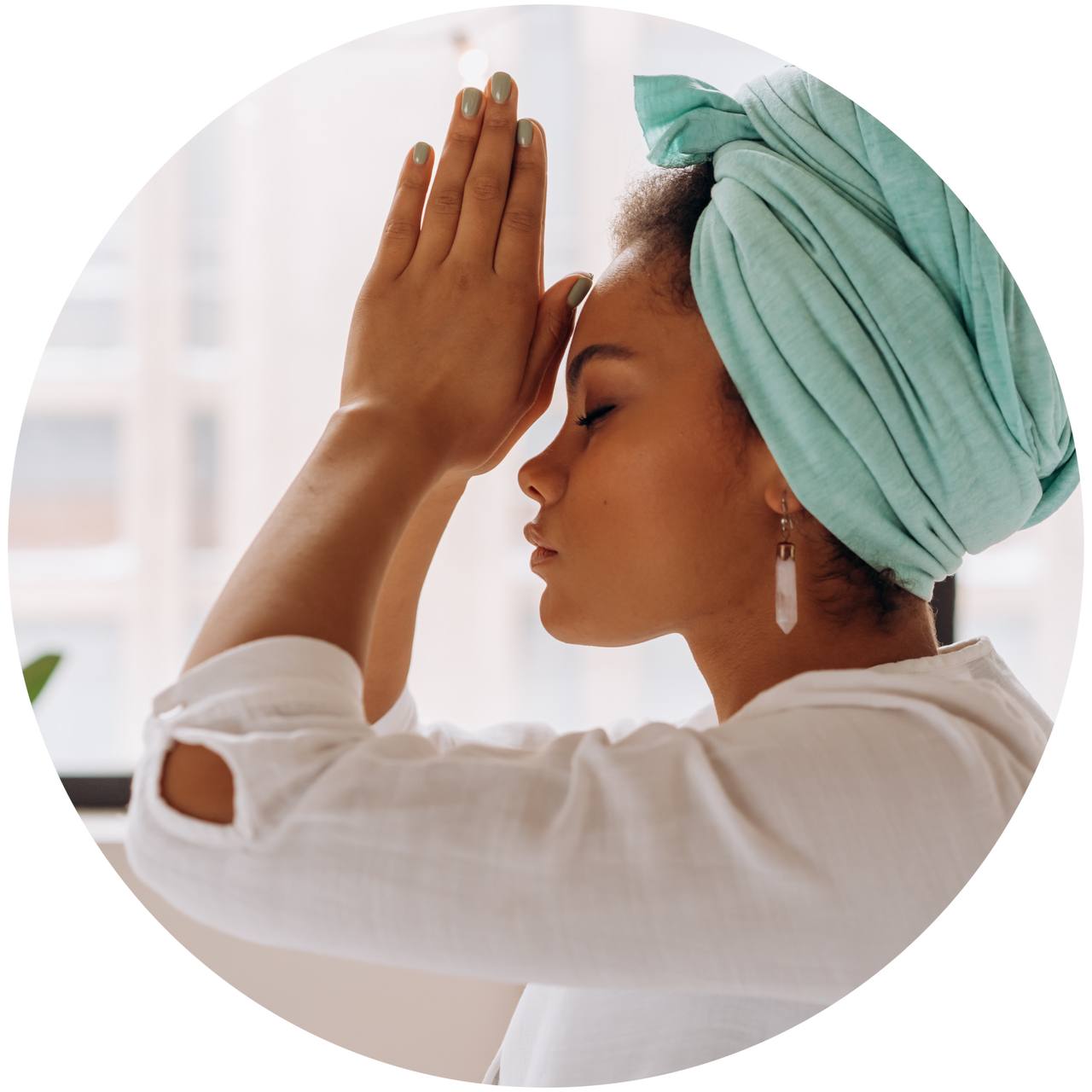 Woman with her hands in prayer position at her third eye chakra