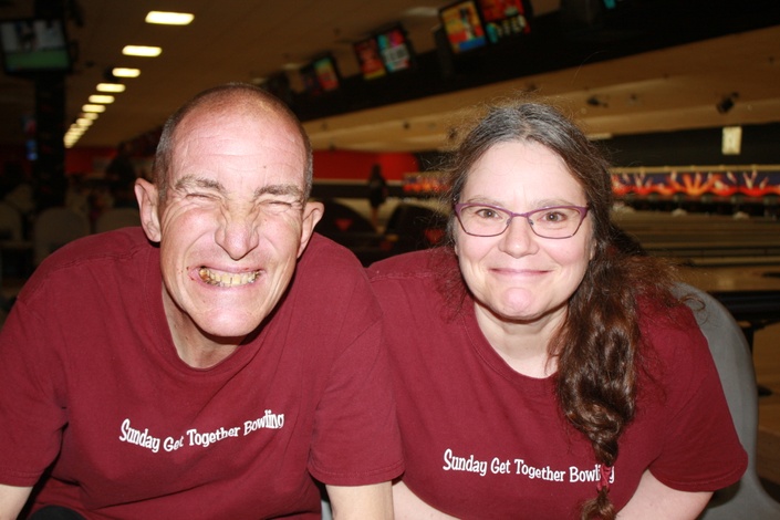 A middle aged man and women smiling at the camera