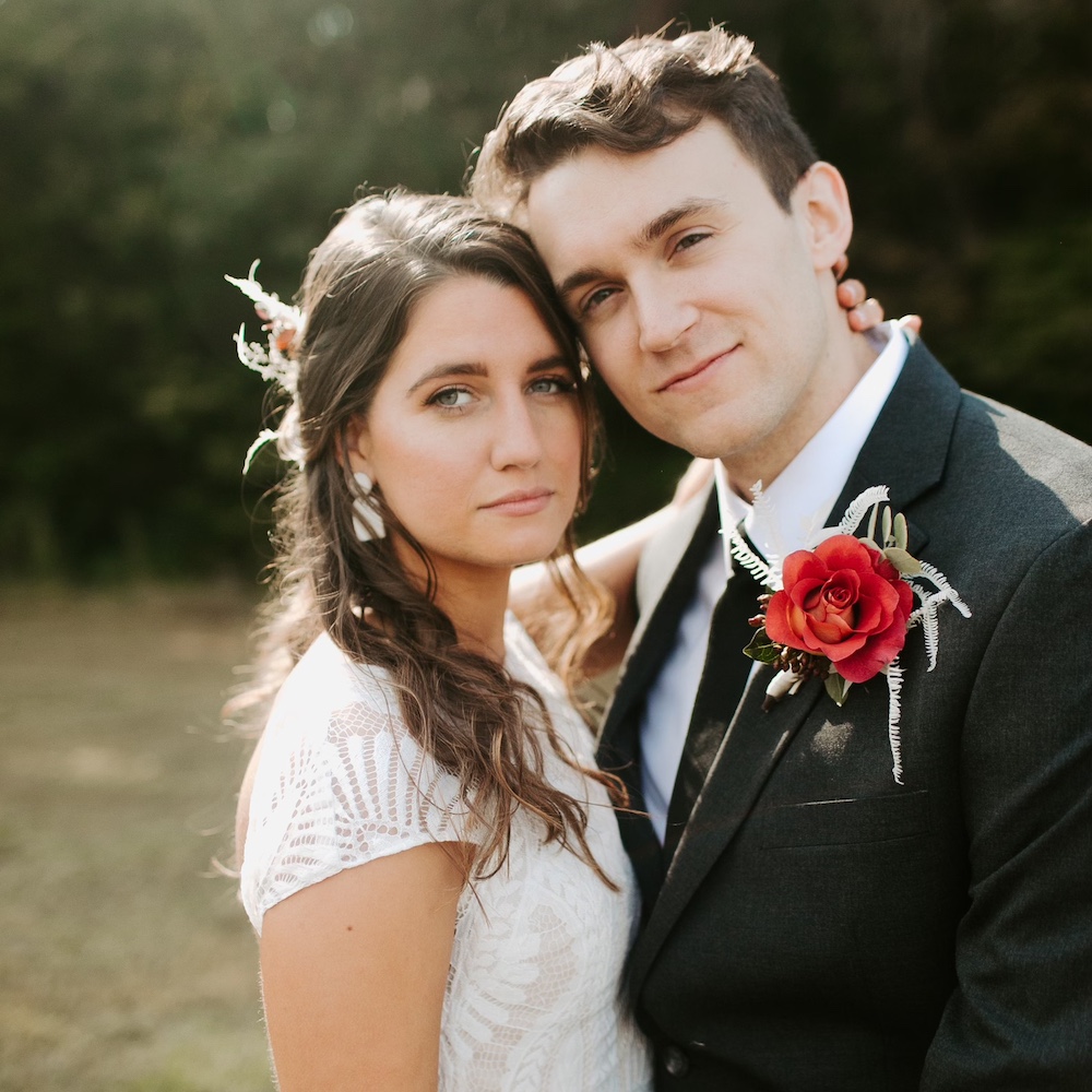 A young couple look at the camera on their wedding day