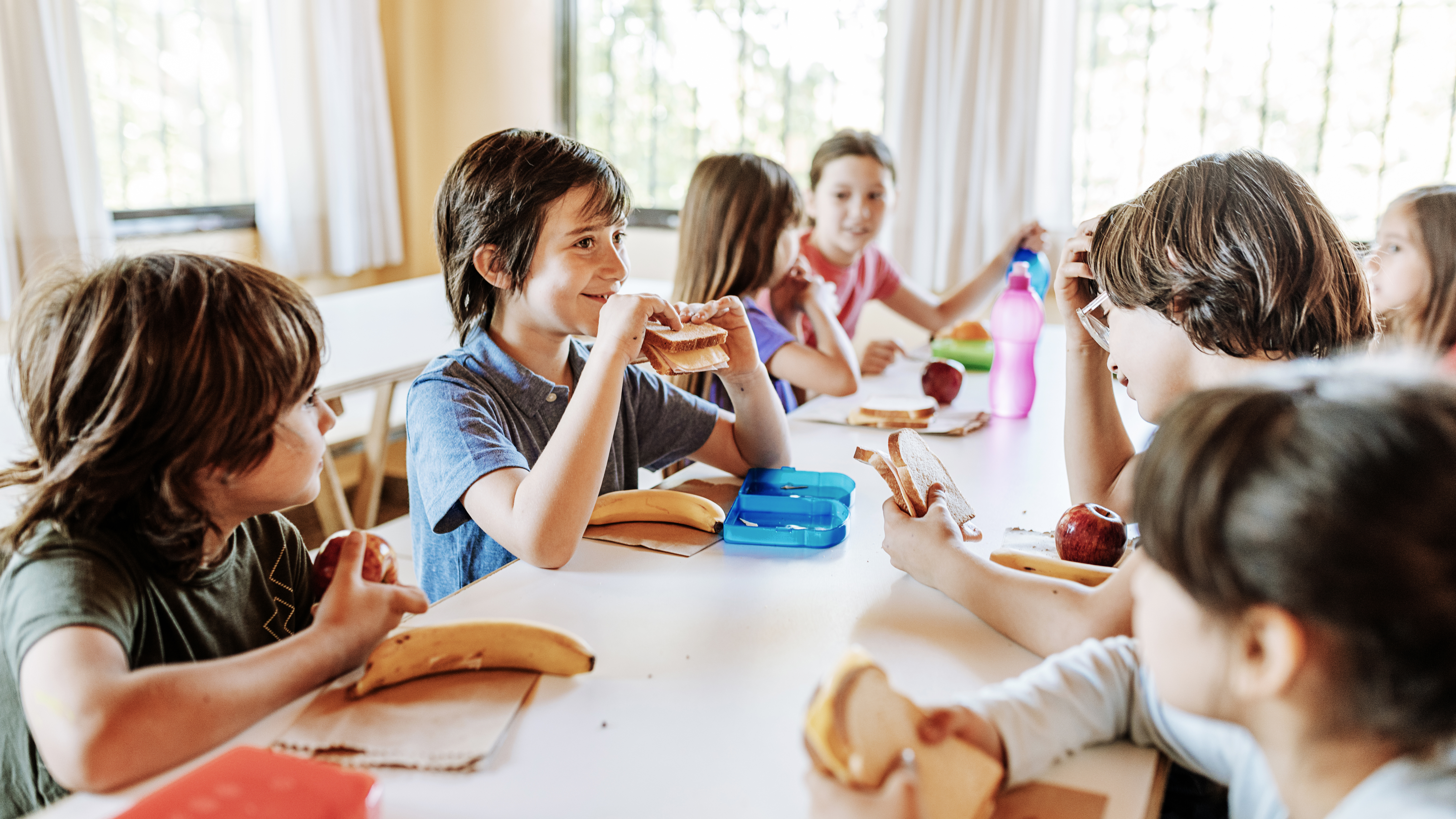 student smiling eating lunch in cafeteria