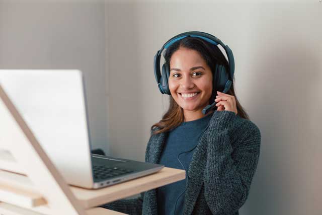 Remote Worker at laptop smiling with headset