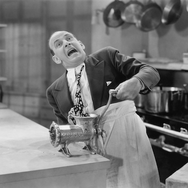 comedy image of man with tie trapped in meat grinder