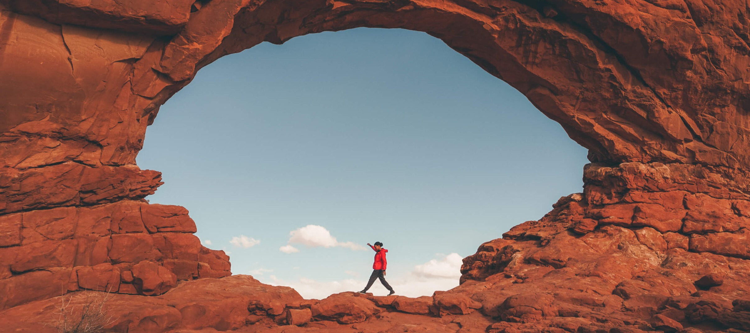 Woman hiking outdoors along rocks in arches national park