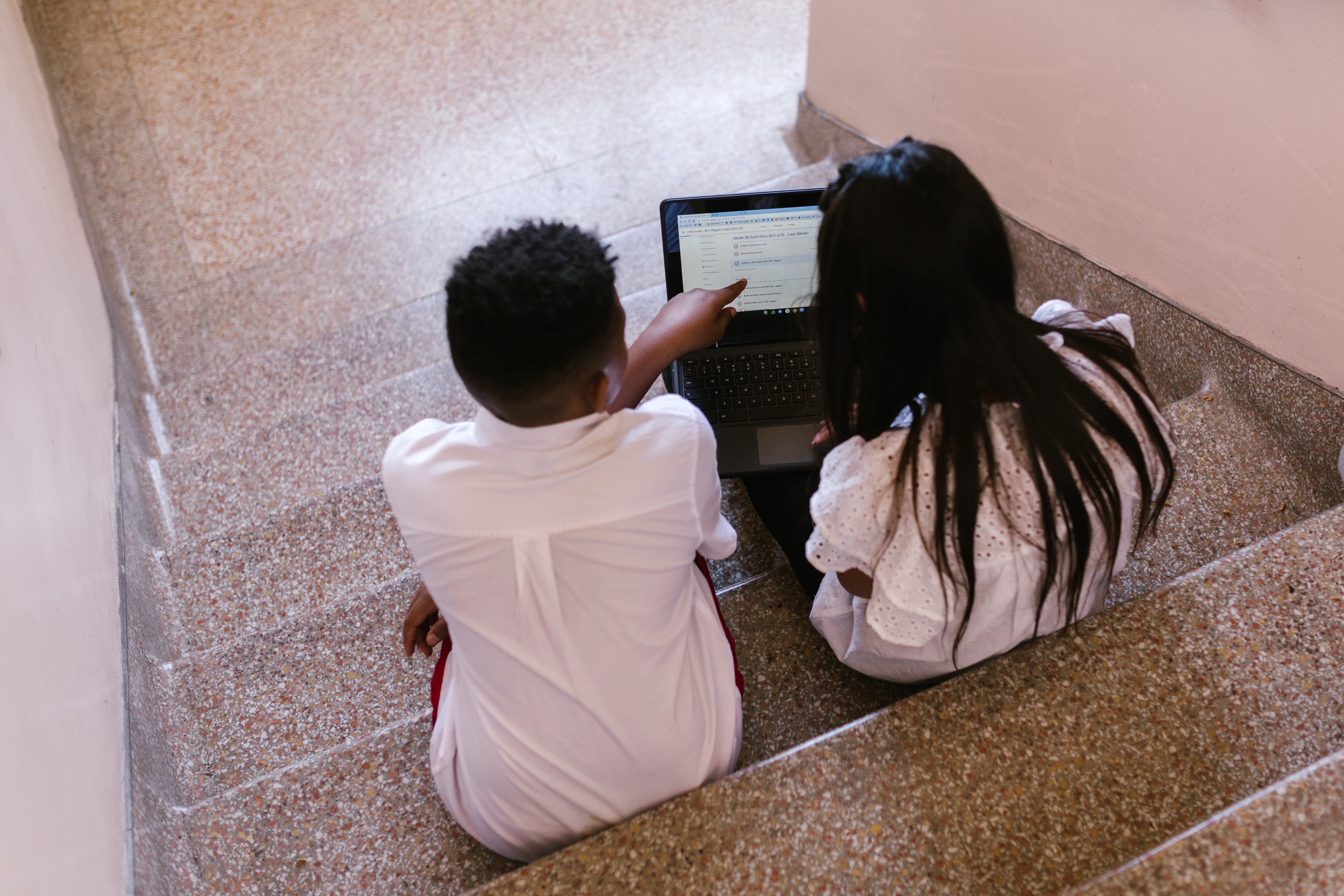 two kids looking at laptop together
