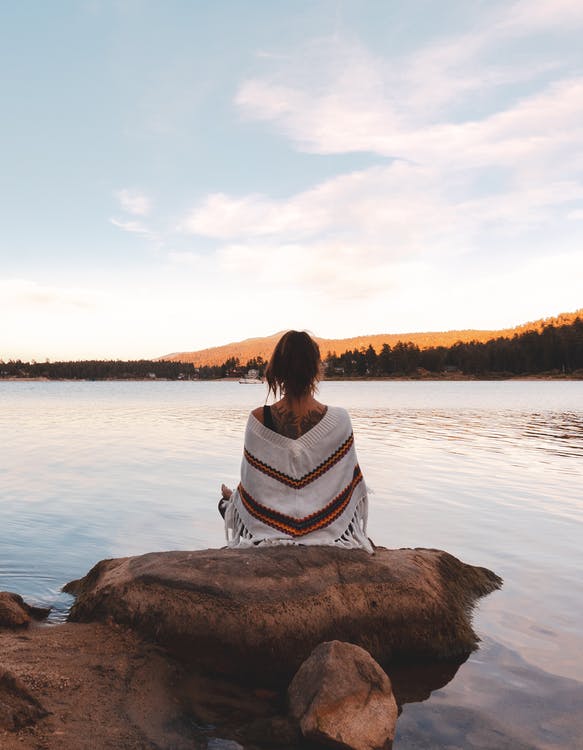 Girl meditating by the lake