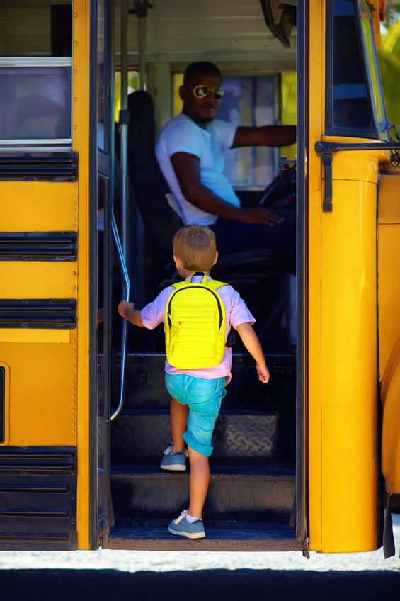 a young man entering the bus via the front steps